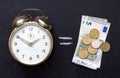 Time is money concept with clock alarm and euro on blackboard Royalty Free Stock Photo