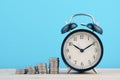 Time is Money concept, stacking coins and alarm clock on wooden Royalty Free Stock Photo