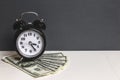 Time and money. Dollars cash. Retro alarm clock and cash money on table. Royalty Free Stock Photo