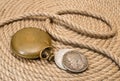 'Time is money' - old pocket watch and silver coins on hemp rope background Royalty Free Stock Photo