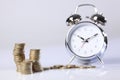 Time is money silver alarm clock and pound coins Royalty Free Stock Photo