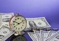 Time is money, vintage clock on cash american dollar bills and coins with nice blue background. Business Commerce concept Royalty Free Stock Photo