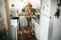 That time of the morning again. two young men making food together in the kitchen at home with their dog during the day.