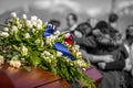 Funeral Casket In Color and Focus, With Family Mourning in Background Out of Focus and In Black And White Royalty Free Stock Photo