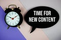 Time For New Content text on speech bubble with alarm clock top view on purple geometric background Royalty Free Stock Photo