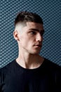 Time for new haircut. Portrait of a handsome young man in black T-shirt with stylish haircut looking away while posing Royalty Free Stock Photo