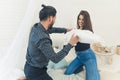 Time for pillow fight. Cute heterosexual couple fighting in their bed. Two friends - long-haired beautiful woman in Royalty Free Stock Photo