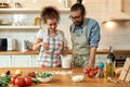 Time for pizza. Young couple in love preparing the dough for making pizza with vegetables at home. Man and woman wearing Royalty Free Stock Photo