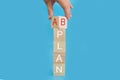 Time for Plan B. The hand rotates the cube and changes the word Plan A to Plan B. Beautiful blue background. Business concept. Cop Royalty Free Stock Photo