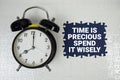 Time Is Precious Spend It Wisely text with alarm clock on blue background Royalty Free Stock Photo