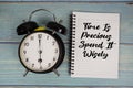 Time is Precious Spend It Wisely text written on notepad with alarm clock on wooden background Royalty Free Stock Photo