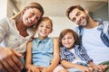 Time is precious, thats why we spend it together. a happy family of four relaxing together on the sofa at home. Royalty Free Stock Photo