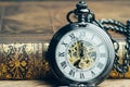 Time running, deadline, life time or business milestone concept, closed up vintage pocket watch or clock on book in vintage tone Royalty Free Stock Photo