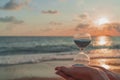 Time is running fast. Hourglass in the hands symbolize the the brevity of life. Background is seacoast and beautiful red sunset