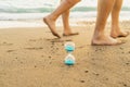 Time is running fast. Hourglass on the wet sea sand and traces of leaving legs symbolize the transience of time Royalty Free Stock Photo