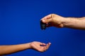 Time for Senior to Hand Over keys to the Car to His Daugther. Isolated on blue studio background Royalty Free Stock Photo