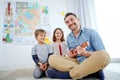 Time spent with my family is worth every second. a happy father playing the guitar for his son and daughter at home. Royalty Free Stock Photo