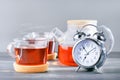 Time for tea, alarm clock and tea cups, teapot with hot tea Royalty Free Stock Photo