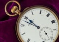 Technology / time: Two minutes to midnight. Close up of a pocket watch on magenta velvet. 2