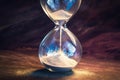 Time ticking Modern hourglass in running time on a wooden table Royalty Free Stock Photo