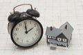 Time to buy a house, A gray house and alarm clock on stone background Royalty Free Stock Photo