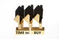 Time to buy house symbol. Concept words `Time to buy` on wooden blocks near miniature houses from shadows. Beautiful white Royalty Free Stock Photo