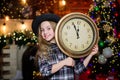 Time to celebrate. Happy new year. cowgirl child with big clock. Xmas tree. Happy holiday. Little girl in cowboy hat Royalty Free Stock Photo