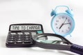 TIME TO CHANGE text on calculator display, blurred focus of clock and magnifier on white background Royalty Free Stock Photo