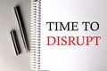 TIME TO DISRUPT text on a notebook with pen on grey background Royalty Free Stock Photo