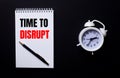 TIME TO DISRUPT is written in a white notepad near a white alarm clock on a black background Royalty Free Stock Photo
