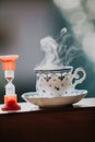 Elegant tea cup and hourglass stand shelf Royalty Free Stock Photo