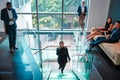 Time to get down to business. a young businesswoman walking up the stairs while using a phone in a busy office at work. Royalty Free Stock Photo