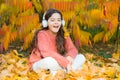 It is time to get in the mood with some great music. Kid girl relaxing near autumn tree with headphones. Music for Royalty Free Stock Photo