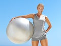 Time to get my fitness on. Portrait of fit young woman holding an exercise ball against a blue sky. Royalty Free Stock Photo