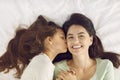 Little daughter wakes up her happy mum with a kiss on the morning of Mother& x27;s Day Royalty Free Stock Photo