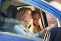 Time to hit the mall. two young women traveling in a car in the city. Royalty Free Stock Photo