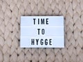 TIME TO HYGGE word on lightbox on knit background. Cozy compozition. Knit background.
