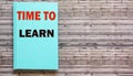 Time to Learn written on a green notepad and a wooden table Royalty Free Stock Photo