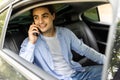 Time to make decision. Confident young businessman working on his laptop and talking on the phone while sitting in the car Royalty Free Stock Photo