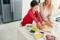 Time to make dinner with my daughter. a middle aged mother and her daughter preparing a pizza to go into the oven in the Royalty Free Stock Photo