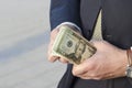 Time to make money. businessman in a suit with a wad of cash. businessman recounts profits.