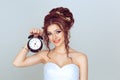 It is time to marry, your biological clock is ticking concept. Young smiling bride woman spouse with alarm clock isolated light