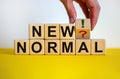 Time to new normal. Male hand turns a cube with question mark and exclamation mark. Words `new normal`. Covid-19 postpandemic Royalty Free Stock Photo