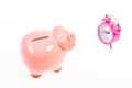 It is time to pay. Piggy bank pink pig and little alarm clock. Financial crisis. Banking account. Bankruptcy and debt