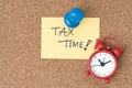Time to planning for tax or reminder for tax payment concept, Thumbtack pushpin with alarm clock on small paper note written the