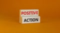 Time to positive action symbol. Wooden blocks with concept words `Positive action`. Beautiful orange background. Business and