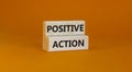 Time to positive action symbol. Wooden blocks with concept words `Positive action`. Beautiful orange background. Business and