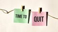 TIME TO QUIT text words inscription on yellow sticker note on white wall or table