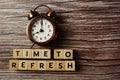 Time To Refresh alphabet letter with alarm clock on wooden background Royalty Free Stock Photo