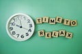 Time To Relax alphabet letter with alarm clock on wooden background